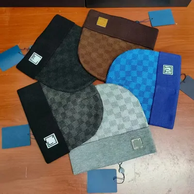 Knitted beanies in brown, blue and black spread out on a table