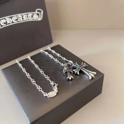Silver chain necklaces with cross pendants laid on a black box