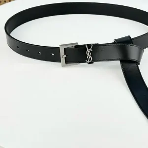 A black belt with its buckle on a light surface